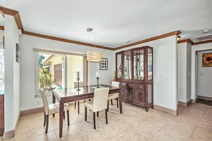 Dining space featuring crown molding and light tile patterned floors