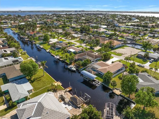 Aerial perspective of suburban area featuring a nearby body of water