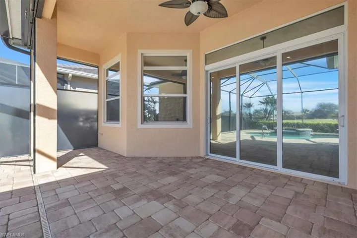 View of patio / terrace featuring a lanai, ceiling fan, a pool with connected hot tub, and a sunroom