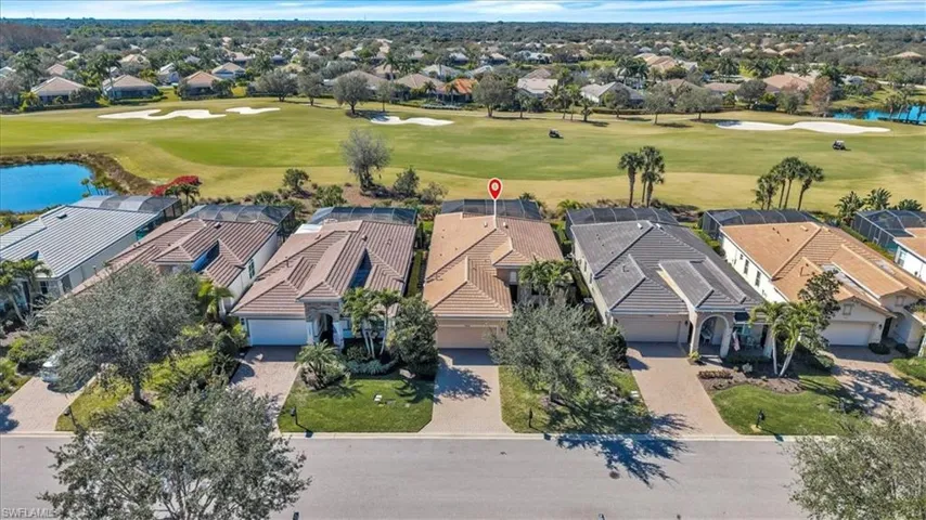 Aerial perspective of suburban area featuring a large body of water and a golf course