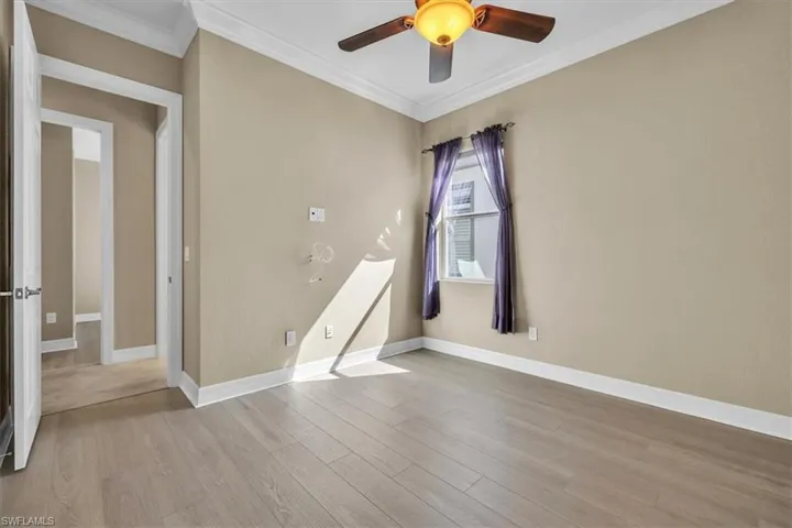 Unfurnished room with crown molding, ceiling fan, and light wood finished floors