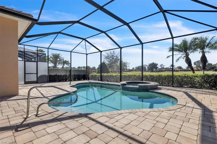 Relaxing pool / spa featuring a sunroom, a patio area, and glass enclosure