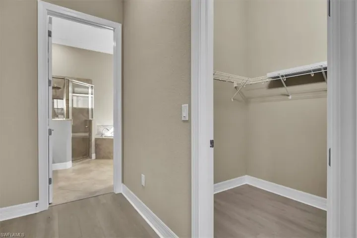 Walk in closet with light wood-style floors