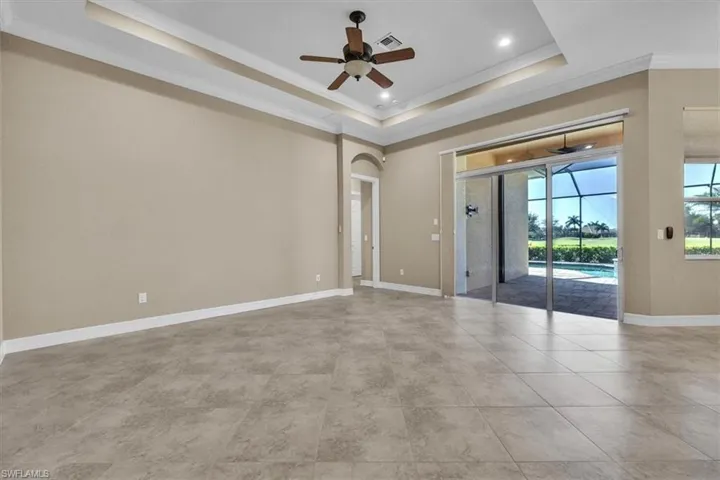 Empty room with a ceiling fan, crown molding, a sunroom, recessed lighting, and arched walkways