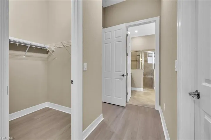 Walk in closet with light wood-style floors