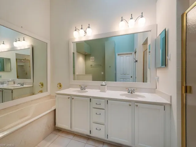 Main Bathroom with high ceilings, skylight, dual sinks vanity, and shower with separate bathtub