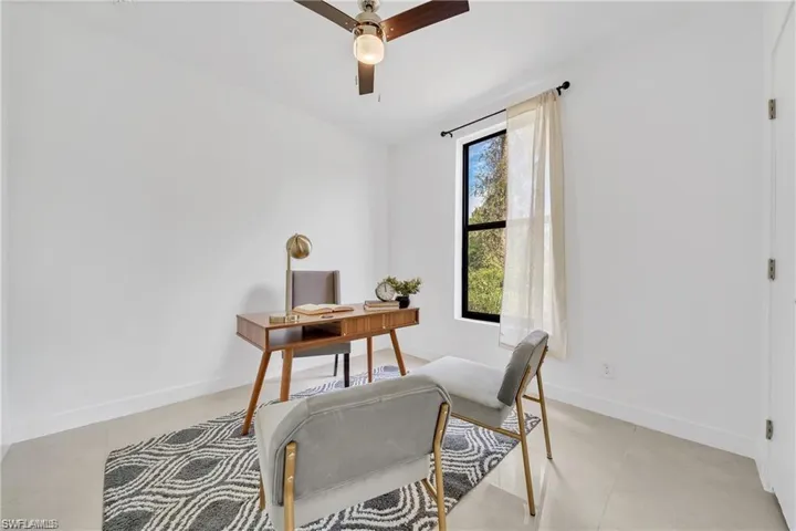 Office with light tile patterned floors, baseboards, and a ceiling fan