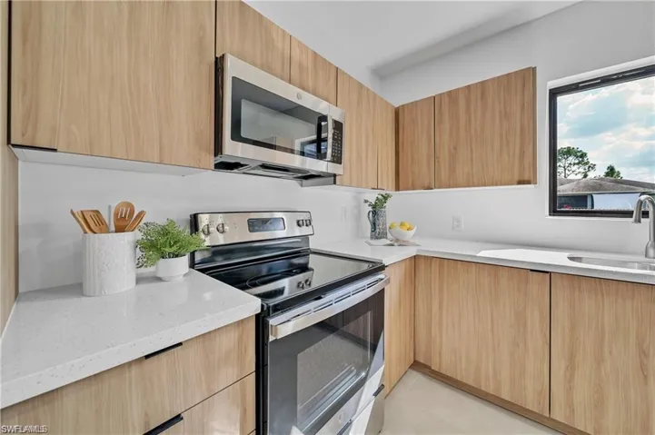 Kitchen featuring light stone counters, modern cabinets, and appliances with stainless steel finishes