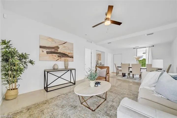 Living area featuring visible vents, tile patterned flooring, and a ceiling fan