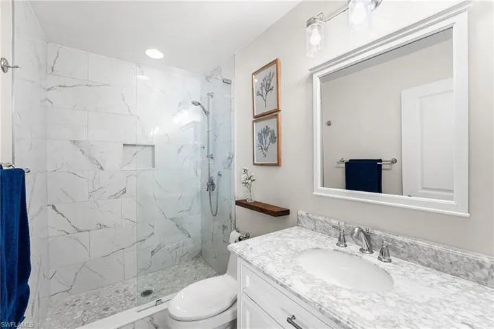 2nd bathroom is ensuite. Floor to ceiling tile in your walk in shower with seamless glass enclosure.. Quartz countertop.