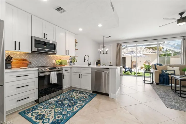 Updated kitchen with white shaker cabinets, quartz countertops and stainless steel appliances