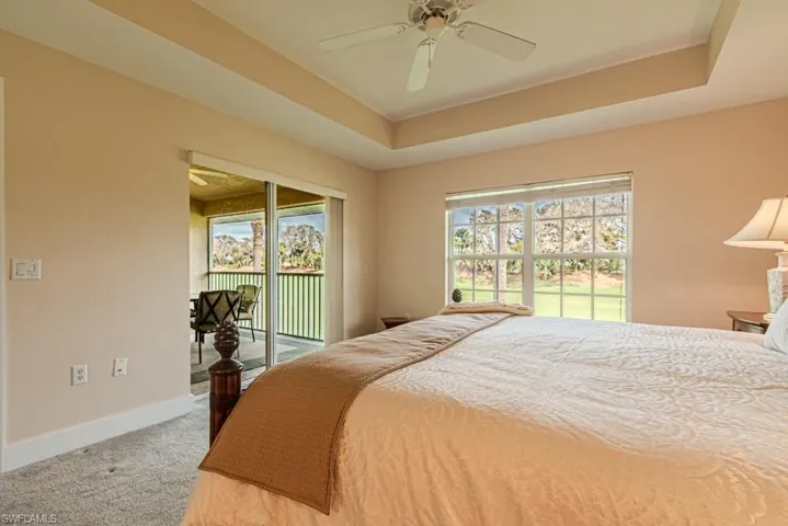 Bedroom featuring ceiling fan, multiple windows, access to outside, and carpet flooring