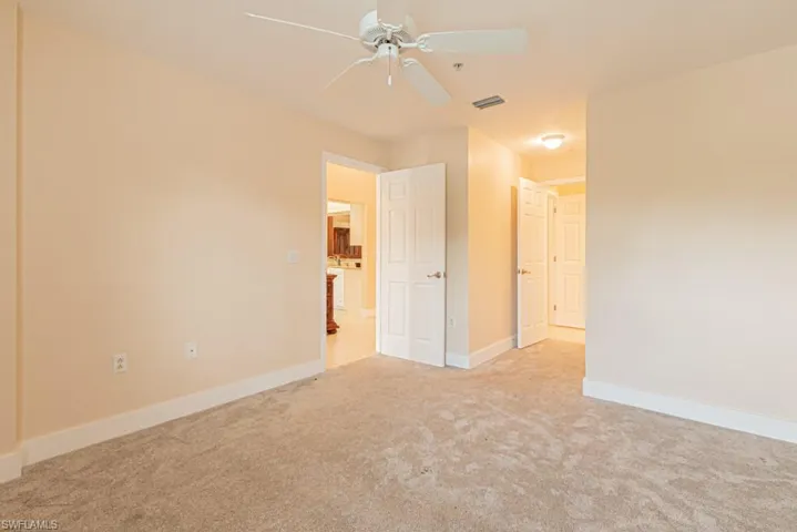 Unfurnished bedroom featuring ceiling fan and light colored carpet