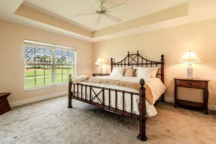 Bedroom featuring ceiling fan, a raised ceiling, and carpet