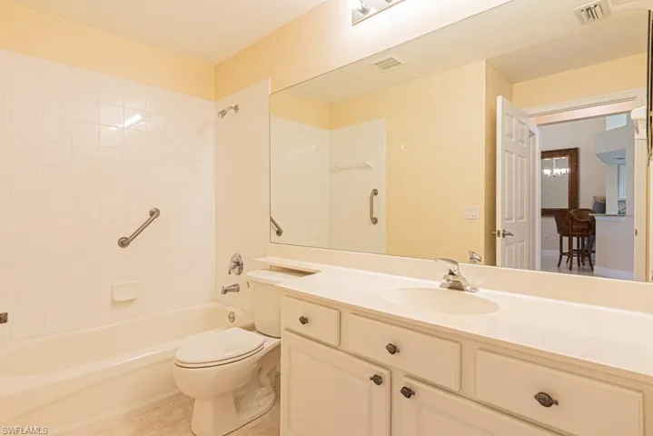 Full bathroom featuring tiled shower / bath, vanity, toilet, and tile patterned floors