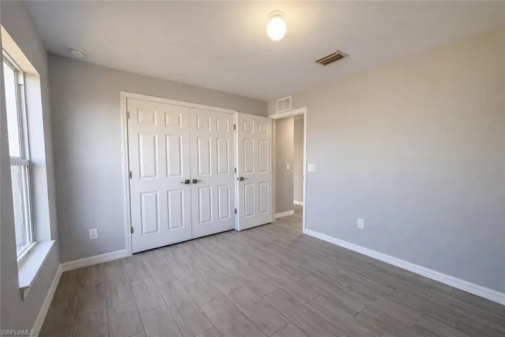 Unfurnished bedroom with wood finish floors and a closet