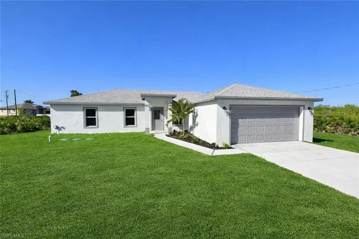 Prairie-style house featuring a front lawn, stucco siding, concrete driveway, and a garage