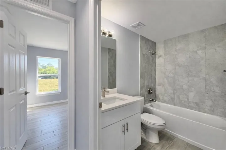 Bathroom with vanity, wood tiled floors, and shower / bath combination