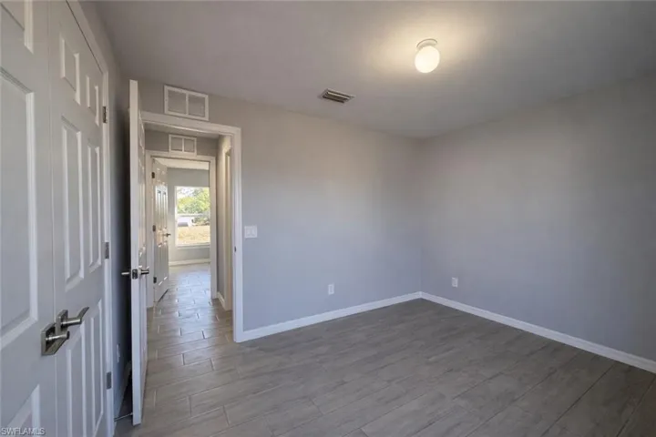 Unfurnished room featuring wood finish floors and baseboards