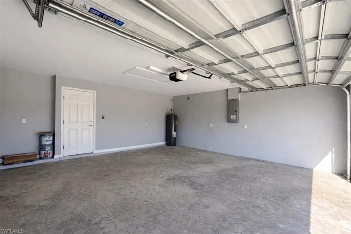 Garage featuring electric panel and electric water heater