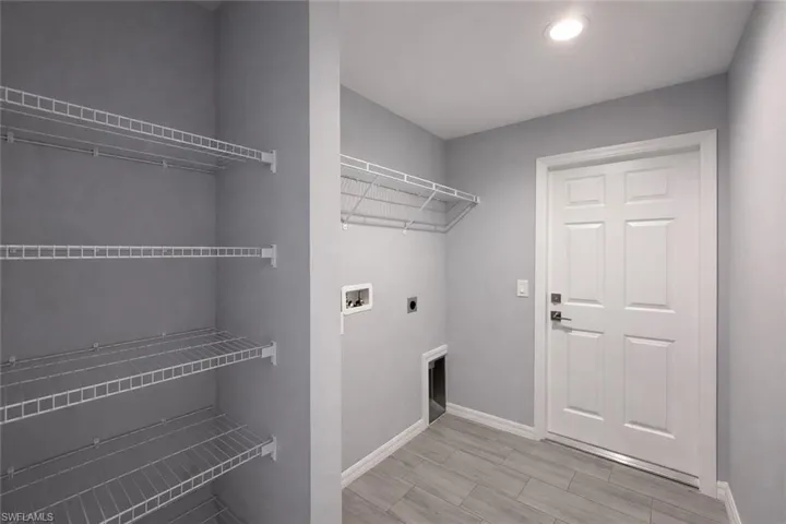 Laundry area featuring hookup for a washing machine, electric dryer hookup, and wood finish floors