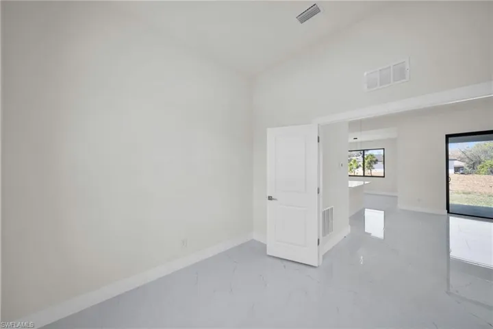 Empty room with light marble finish flooring and a high ceiling