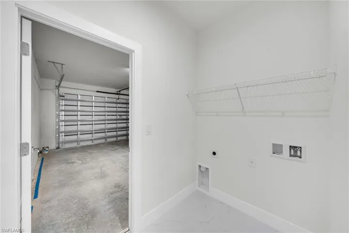 Laundry area with hookup for a washing machine, hookup for an electric dryer, and a garage