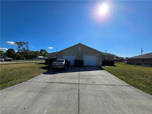 View of front of home featuring concrete driveway, an attached garage, and stucco siding