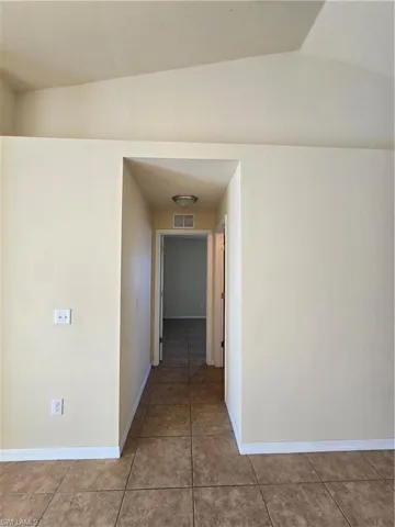 Hallway with baseboards and tile patterned flooring