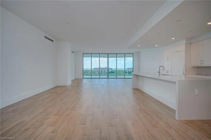 Unfurnished living room featuring floor to ceiling windows and light flooring
