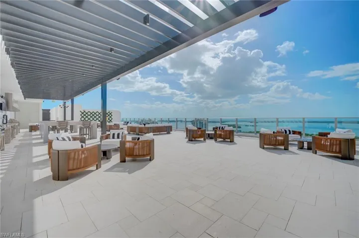 rooftop terrace with outdoor kitchen with grills, outdoor furniture, a water view, and a pergola