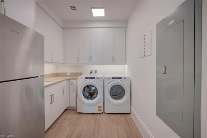 Laundry area with light wood-style flooring and washing machine and dryer