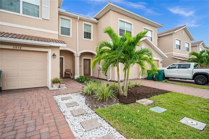 Mediterranean / spanish-style home with stucco siding, decorative driveway, and a front lawn