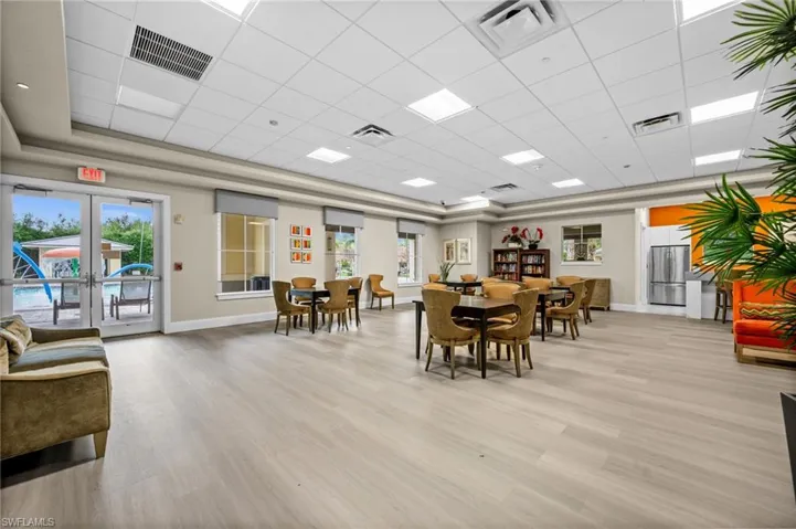 Dining room featuring healthy amount of natural light, light wood-style floors, a paneled ceiling, and a raised ceiling