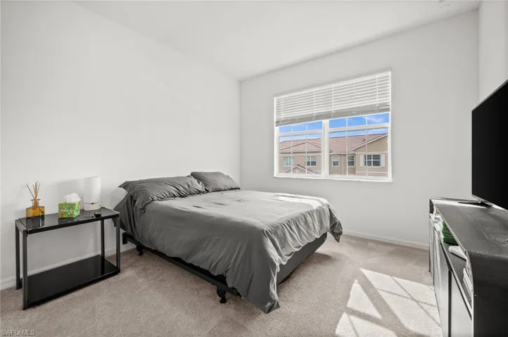 Bedroom with light carpet and baseboards