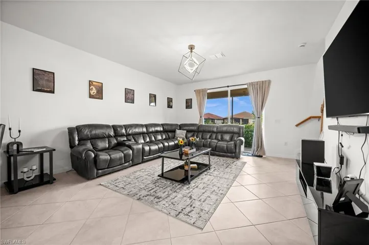 Living room with light tile patterned flooring and baseboards