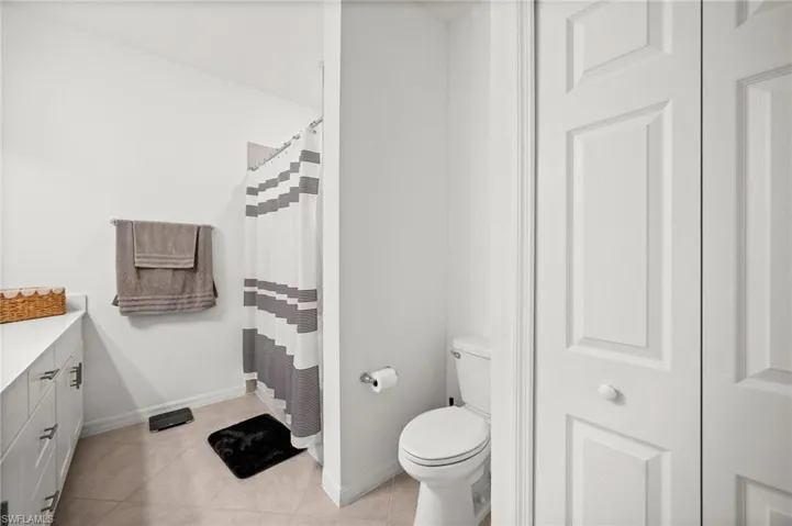 Full bath featuring light tile patterned floors, vanity, and a shower with shower curtain