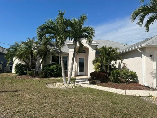 Obstructed view of property with stucco siding and a front lawn