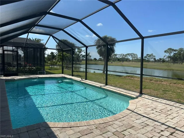 Pool with a water view, a patio area, and glass enclosure