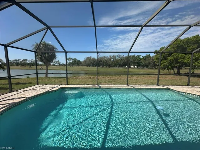 Outdoor pool featuring a water view and a lanai
