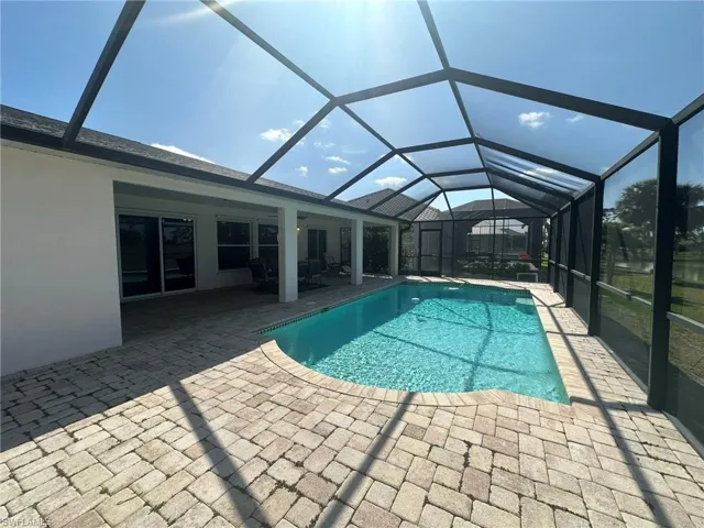 Outdoor pool featuring a patio area and glass enclosure