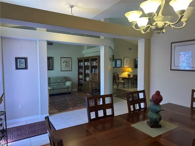 Tiled dining room with visible vents and an inviting chandelier