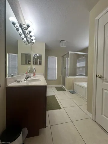Bathroom featuring visible vents, a bath, a textured ceiling, tile patterned floors, and a stall shower