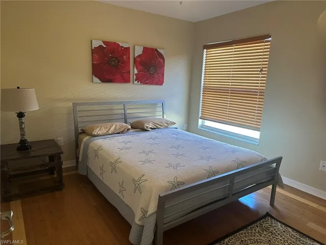Bedroom with wood finished floors and baseboards