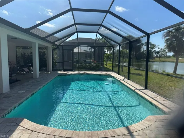 Pool with a water view, a patio, a yard, and a lanai