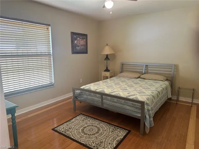 Bedroom featuring baseboards, ceiling fan, and wood finished floors