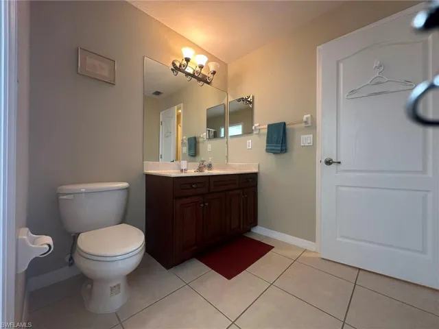 Bathroom with visible vents, baseboards, toilet, vanity, and tile patterned floors