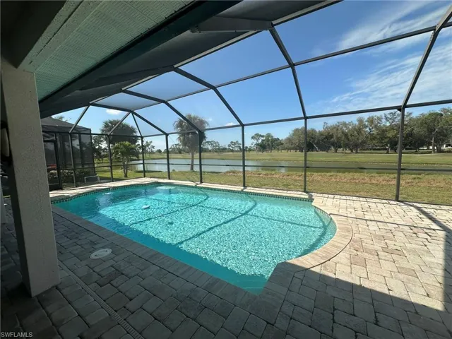 Pool with a water view, a patio, and a lanai