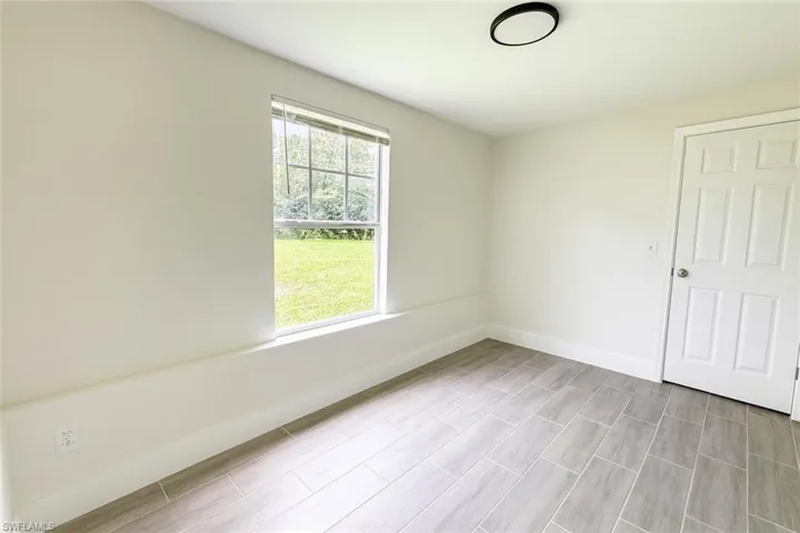 Empty room with baseboards and wood tiled floors