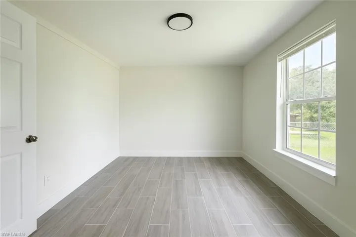 Spare room featuring baseboards and wood tiled floors